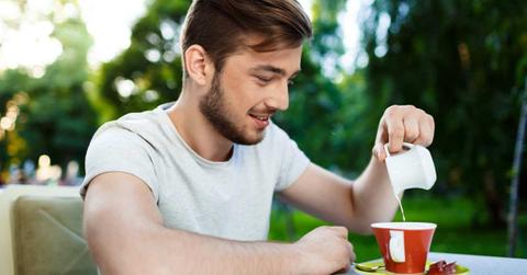A man is pouring milk into his coffee mug. (Representative Cover Image Source: FreePik | cookie_studio)
