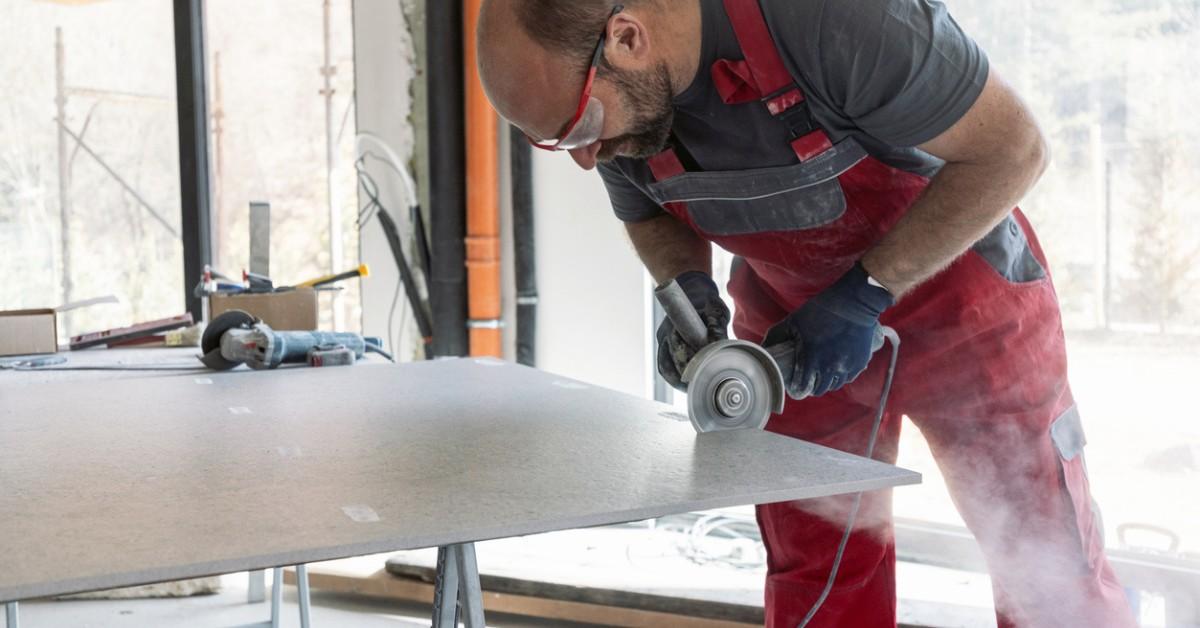 A man cuts a countertop with a saw