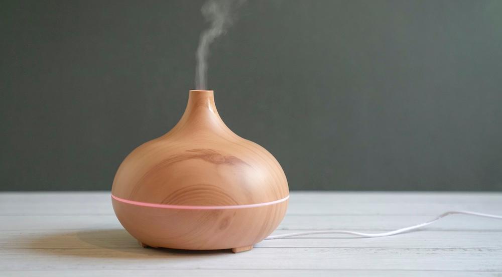 A wooden diffuser on a wooden table. 