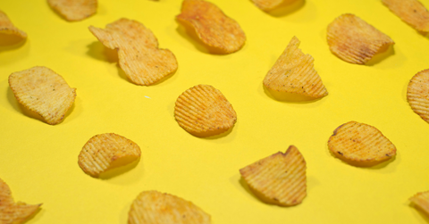 Potato chips sit on a yellow background