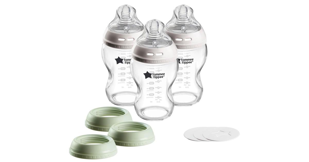 three glass baby bottles with nipples and travel lids