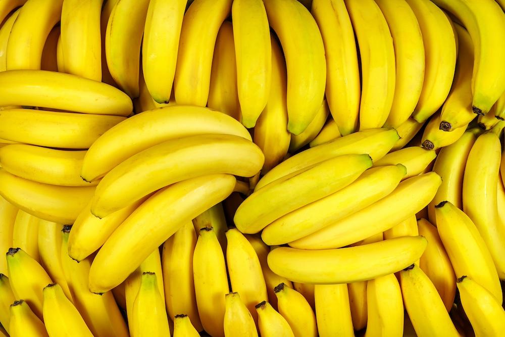 An overhead view of a bunch of dozens of bananas. 