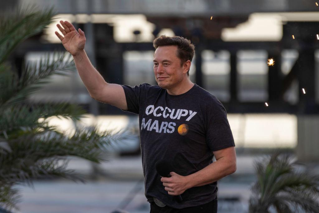 Elon Musk wears a black "Occupy Mars" shirt as he walks on stage during a T-Mobile and SpaceX event in August 2022 in Texas.