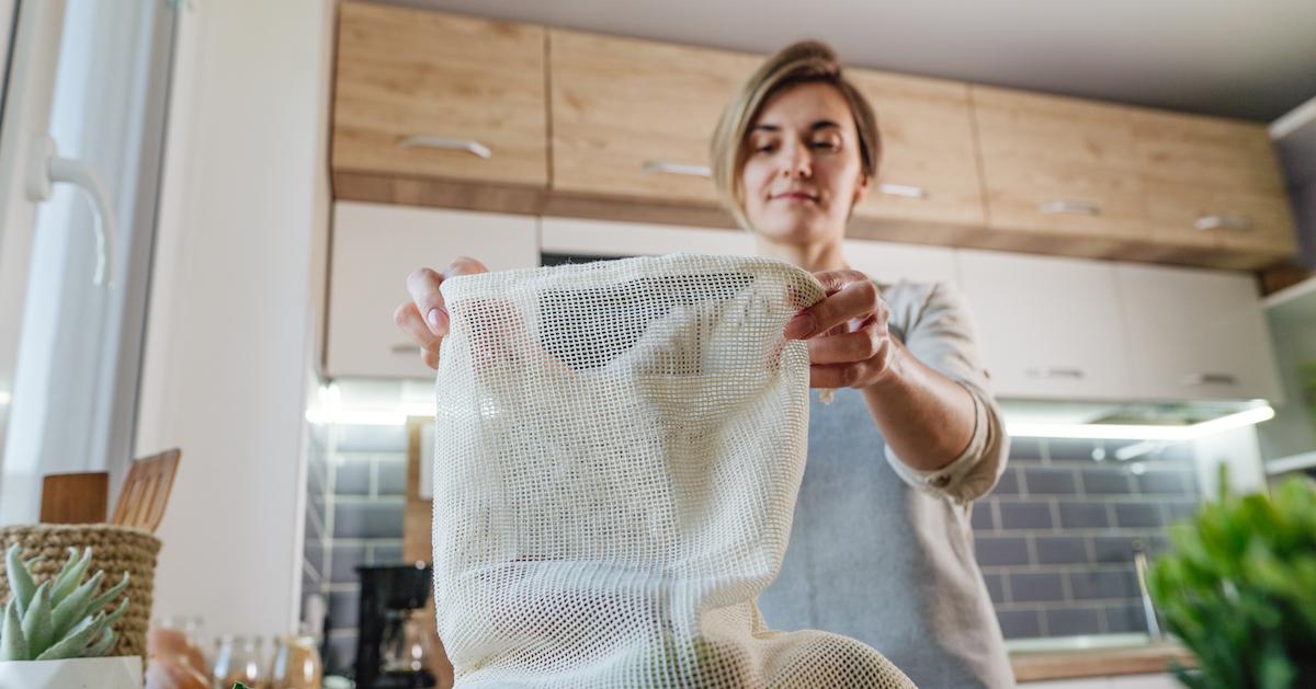 Woman holds a reusable produce bag 