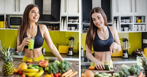 A smiling vegan athlete prepares a fruit and vegetable meal in the kitchen.