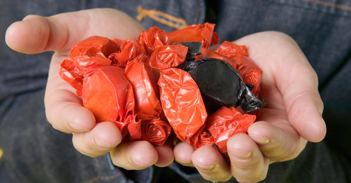 Person holding wrapped orange and black candy.