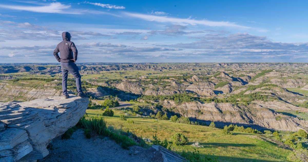 Hills under a cloudy sky dominate the landscape at Theodore Roosevelt National Park (Cover Image Source: Getty Images | GRPimagery)