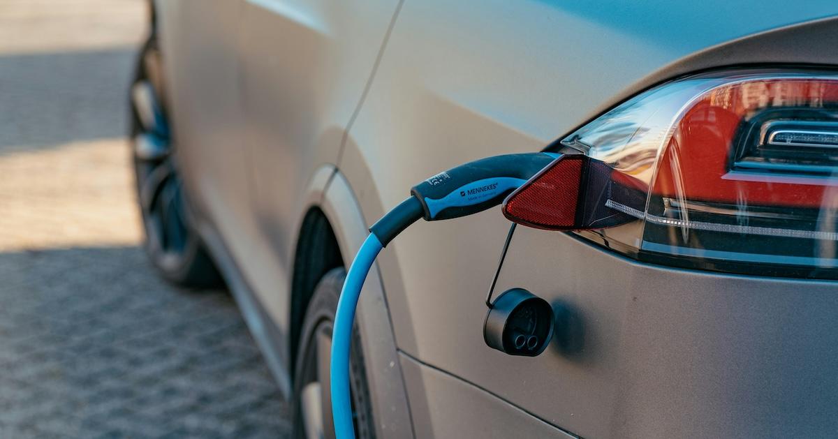 Charging cable plugged into a gray electric car