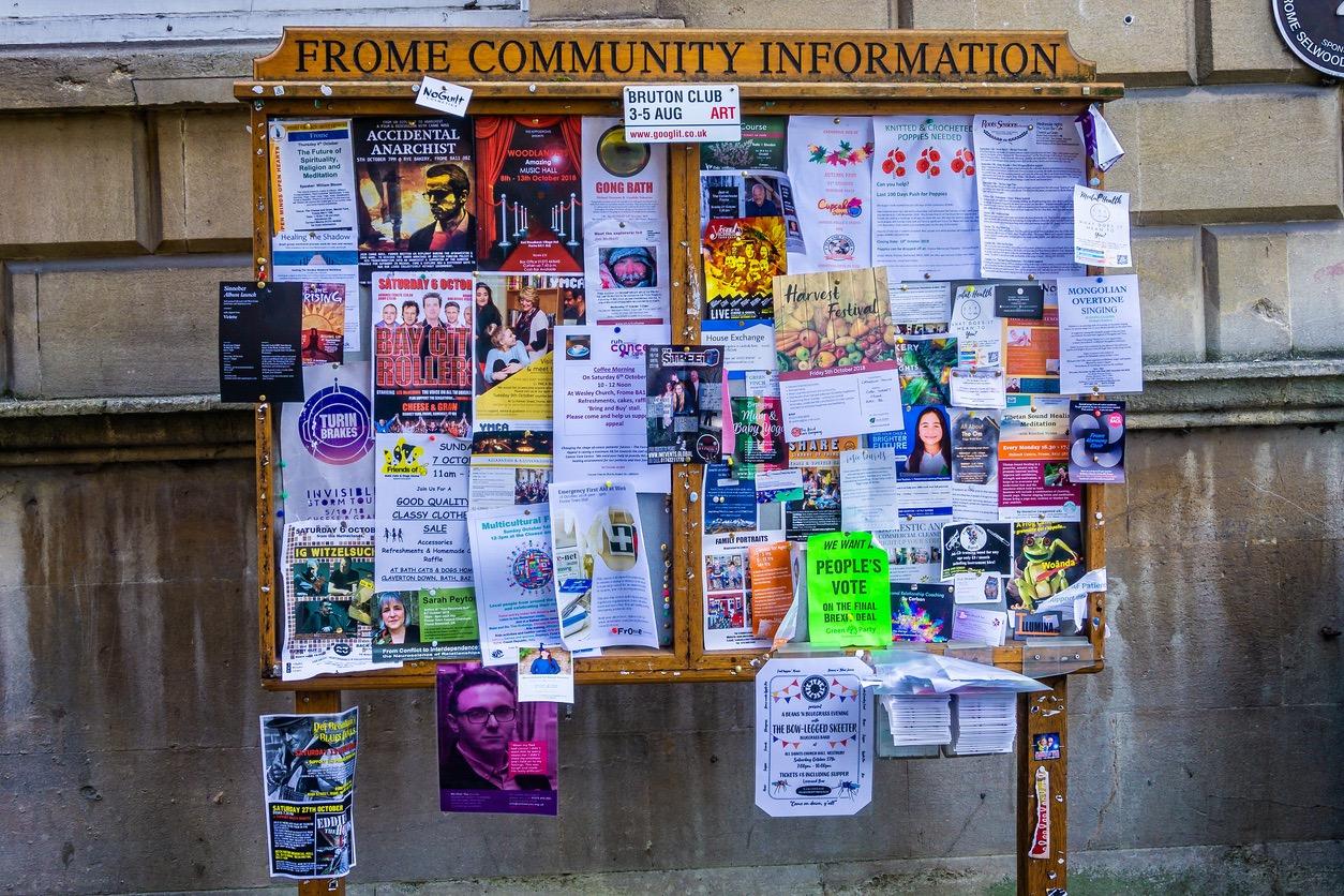 A local bulletin board with community posters and fliers filled with information on events and news.