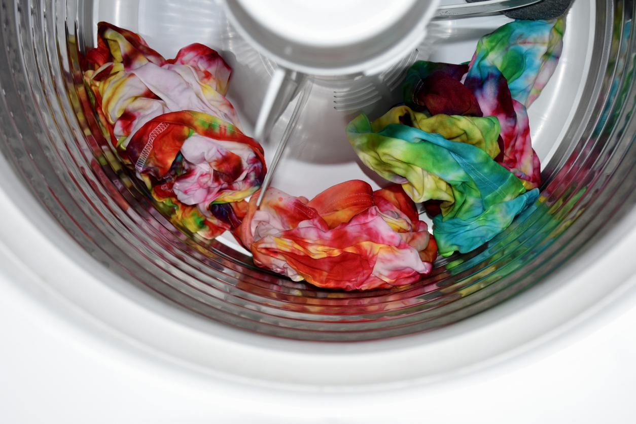 A few tie-dye shirts in a washing machine after a cycle.