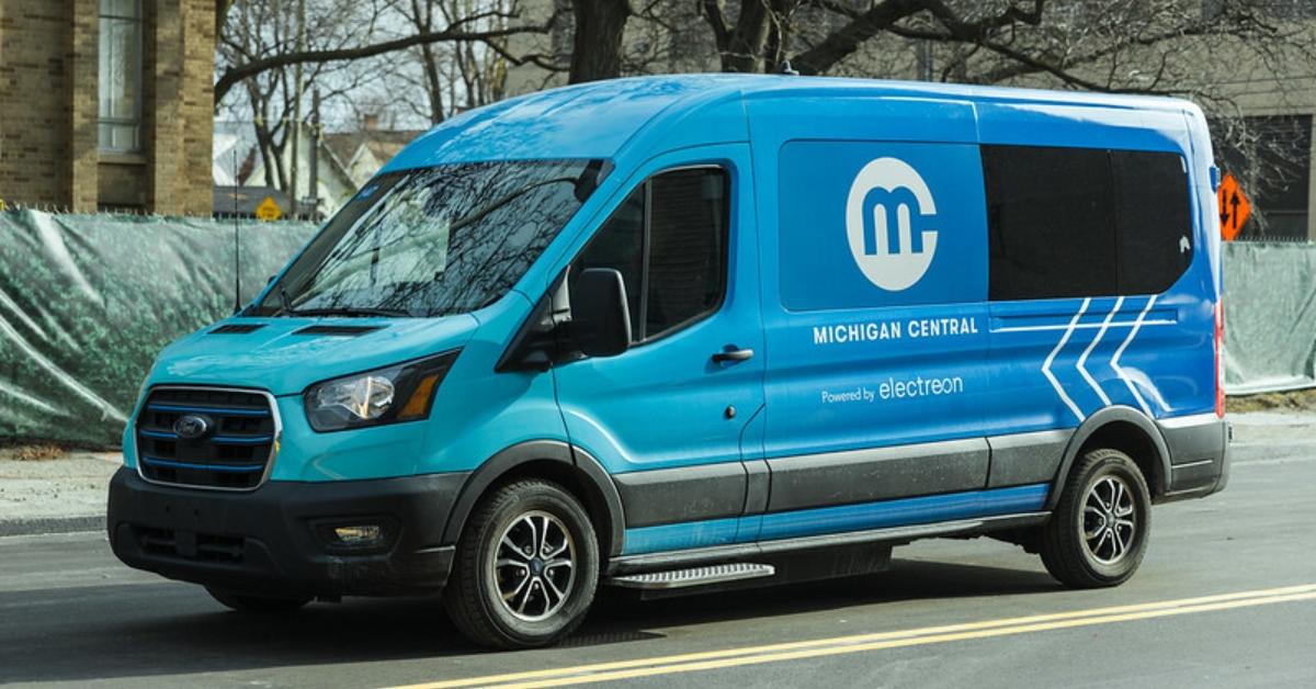 Blue EV van on Detroit's wireless charging road.