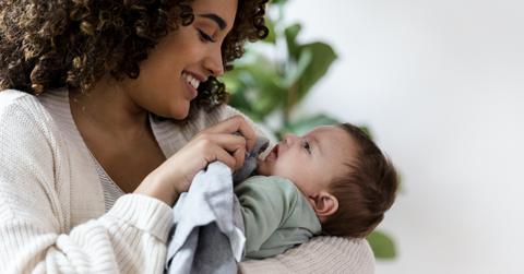 mother wiping baby's face with burp cloth