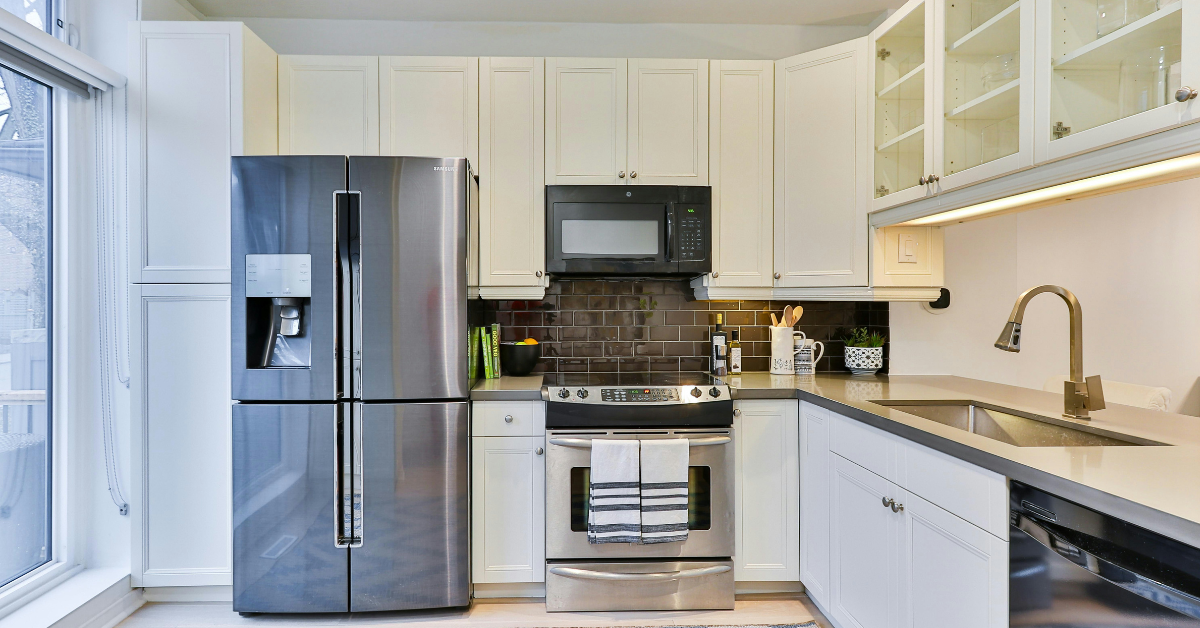 A well lit kitchen features stainless steel appliances