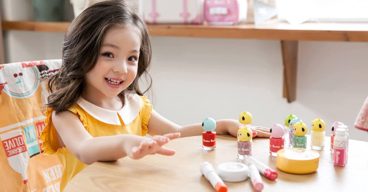 A girl sits at a table with makeup