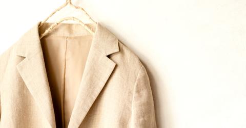 Photo of a natural fiber beige jacket hanging against a wall