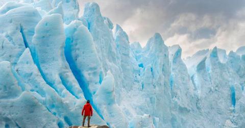 A man is standing in front of a giant ice crevasse. (Representative Cover Image Source: Getty Images | Francesco Vaninetti Photo)