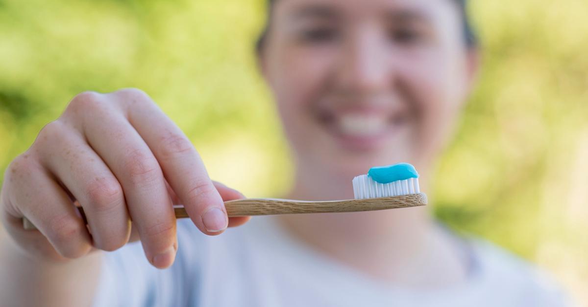 Woman holds sustainable toothbrush