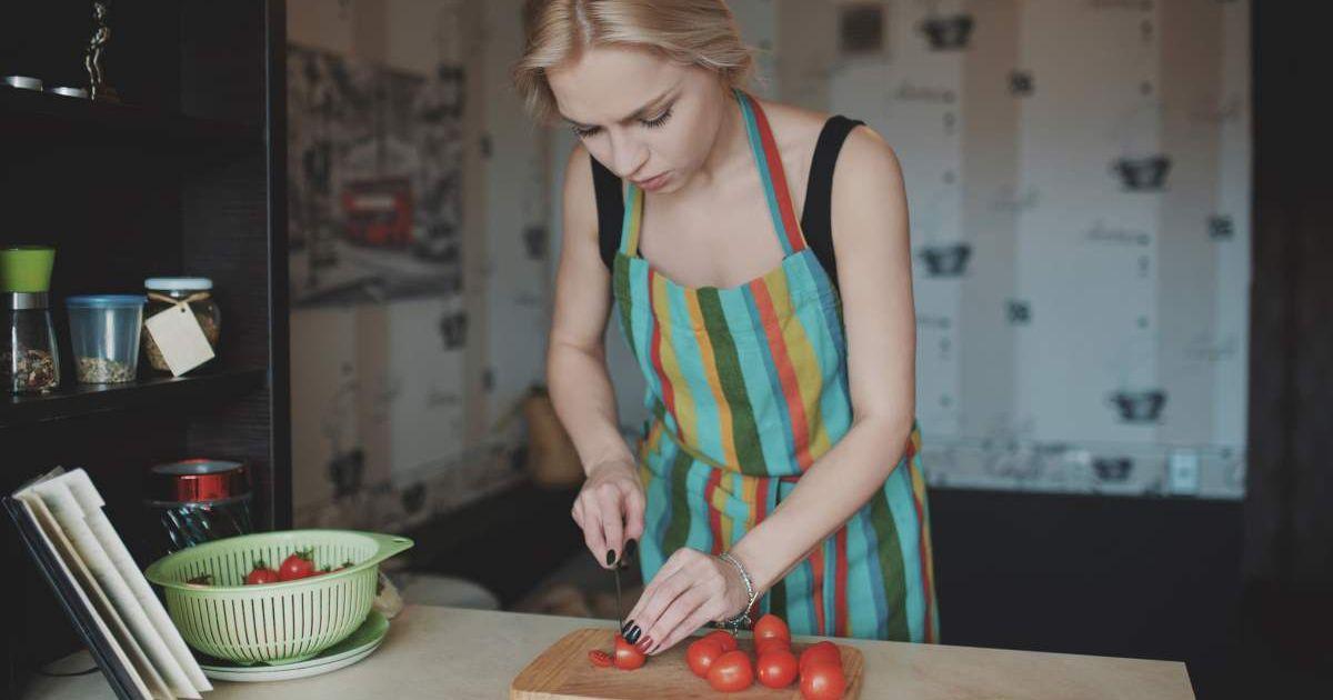 A woman unsure about something while chopping the tomato. (Representative Cover Image Source: Freepik | Arthur Hidden)