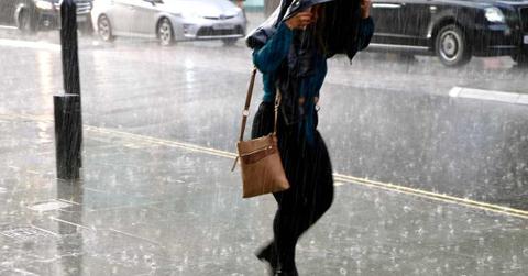 A person walking on the street with their head covered during heavy rain. (Representative Cover Image Source: Getty Images | Simon Shepheard)