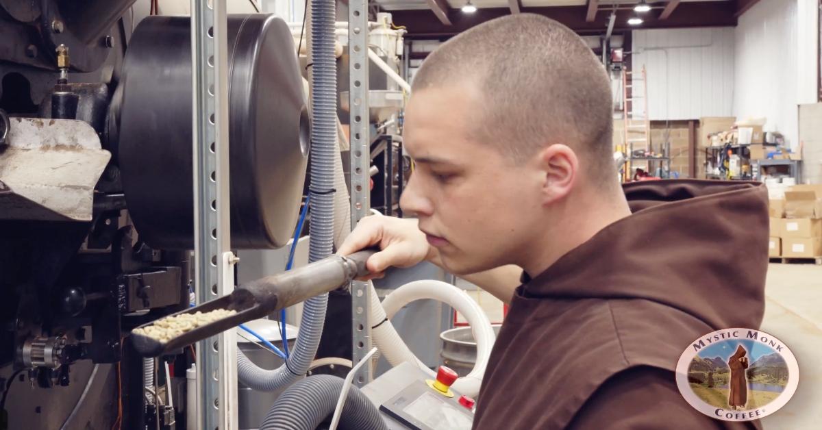 A Carmelite monk observing coffee beans from a roaster.