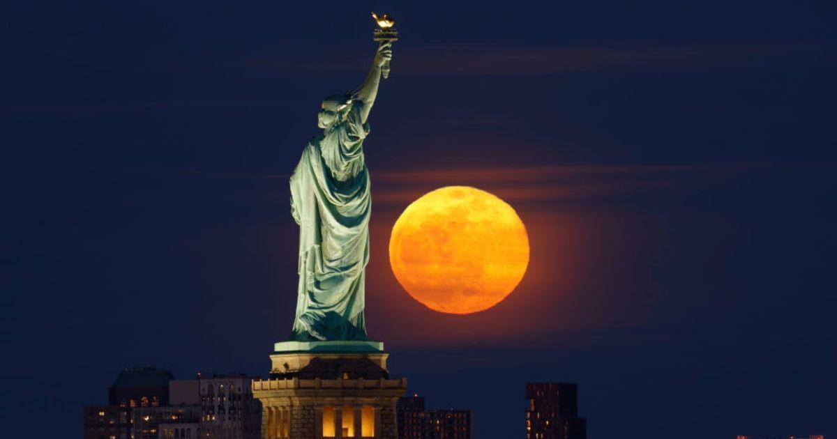The full Snow Moon rises behind the Statue of Liberty and Brooklyn in New York City on February 24, 2024, as seen from Jersey City, New Jersey. (Cover Image Source: Getty Images | Gary Hershorn)