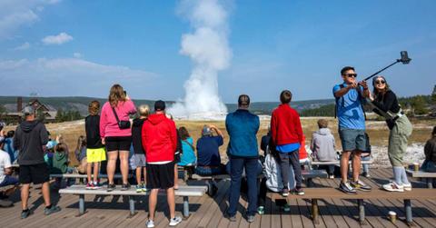Visitors watching a geyser at a national park. (Representative Cover Image Source: Getty Images | Jonathan Newton)