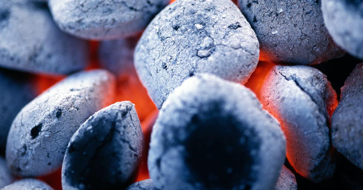 Close-up photograph of charcoal on a grill. 