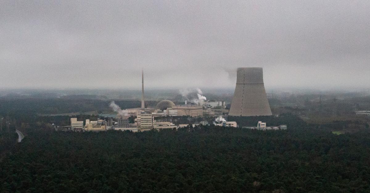 German Nuclear Power Plant in fog, among a forest of trees.