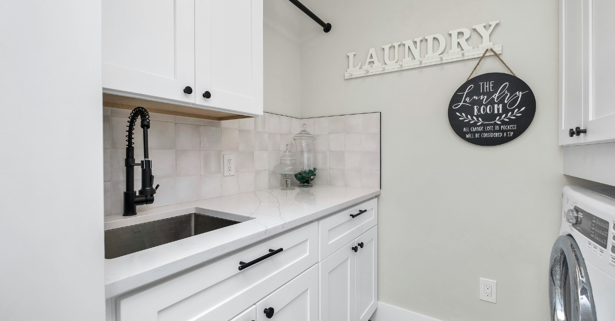 A "laundry room" sign hangs in the middle of a clean and brightly lit wash room