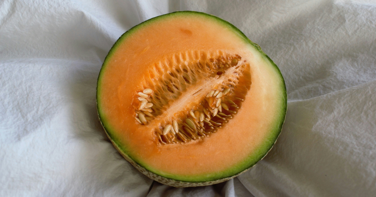 Half a cantaloupe sits on a white sheet