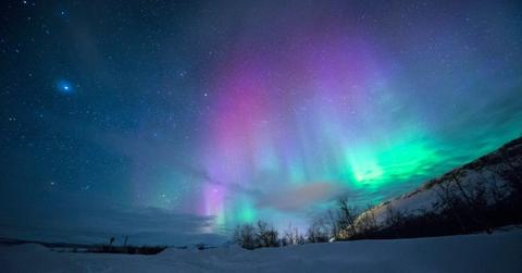 Pinks and greens shine in the night sky thanks to the Northern Lights