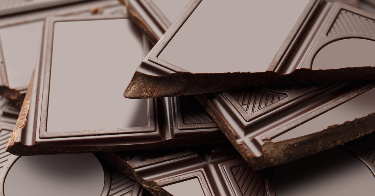 Close-up photograph of broken pieces of dark chocolate bars. 