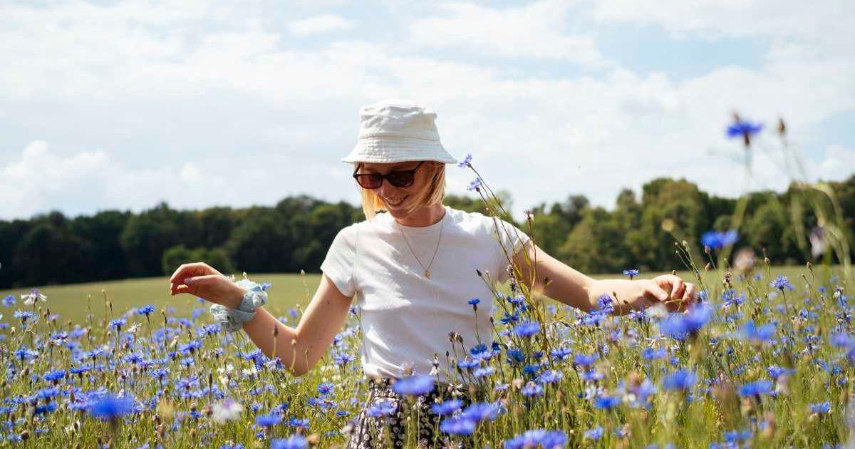 Woman walking amid flowers in a meadow. (Representative Image Source: Getty Images | 	Ivor Ostby Simonsen)