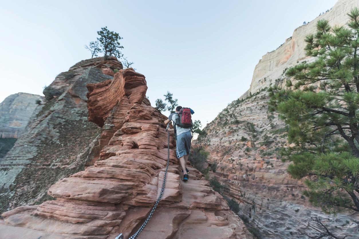 Person hiking on a narrow ledge on Angel's Landing in Zion National Park