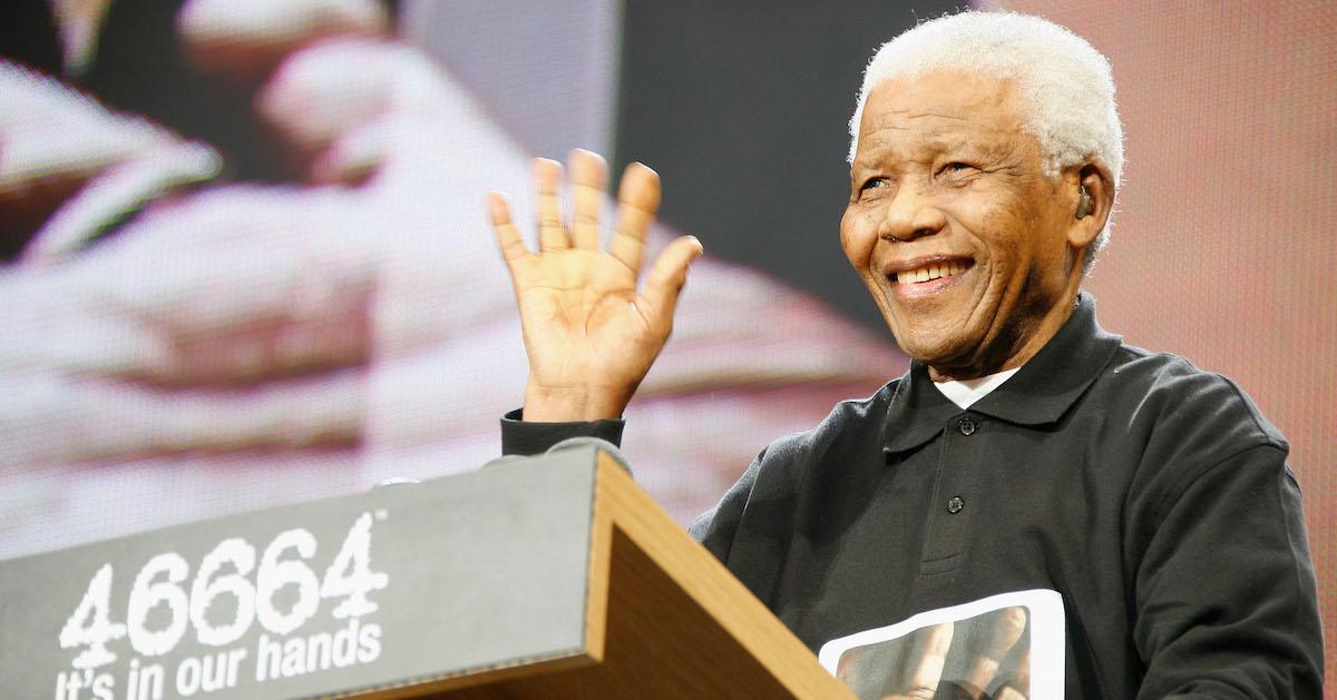 Nelson Mandela smiles and waves from behind a podium