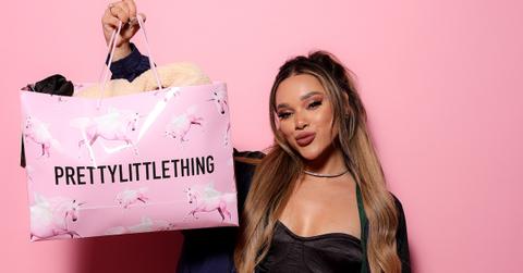 Woman holds up a Pretty Little Thing shopping bag