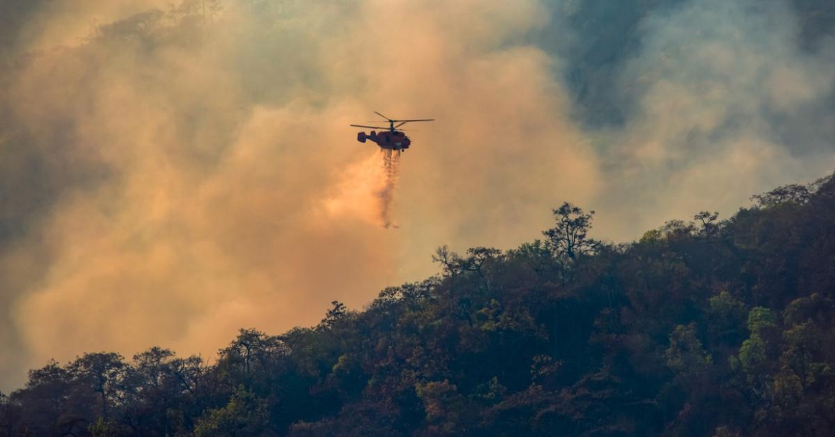 Helicopter drops water on a wildfire. 