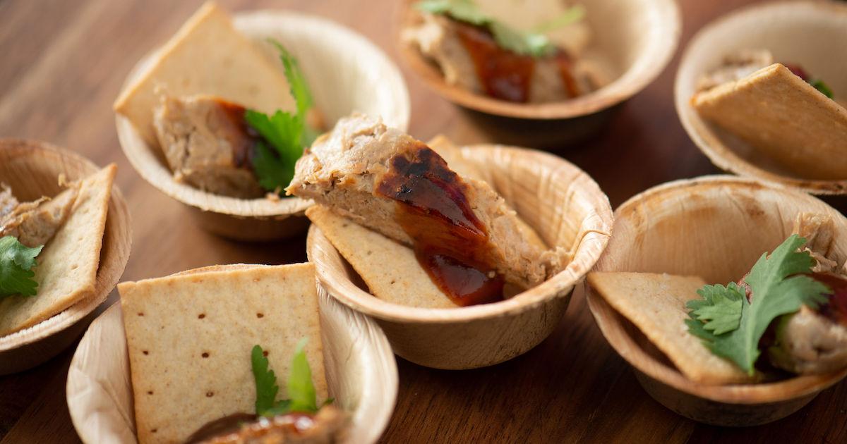 Pieces of Bosque Foods chicken in small wooden bowls with garnish at the Vegan Women Summit