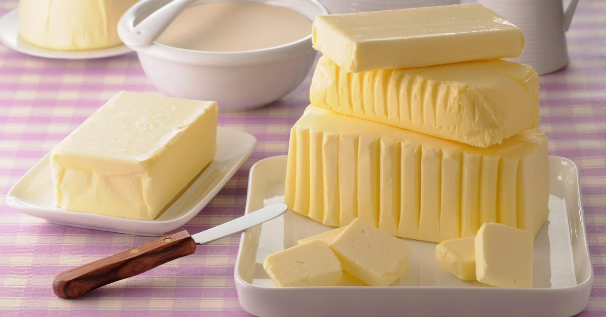 A closeup of an assortment of butter-like spreads on a table with a knife