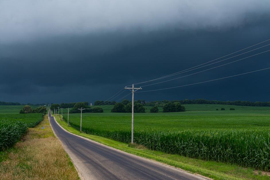 A stock photo of a flat landscape with severe weather in the background. 