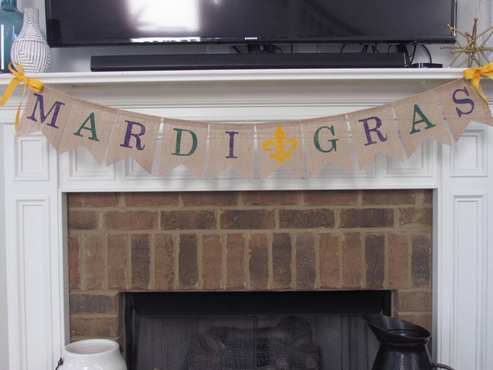 Mardi Gras banner made of burlap and twine, hanging over a fireplace