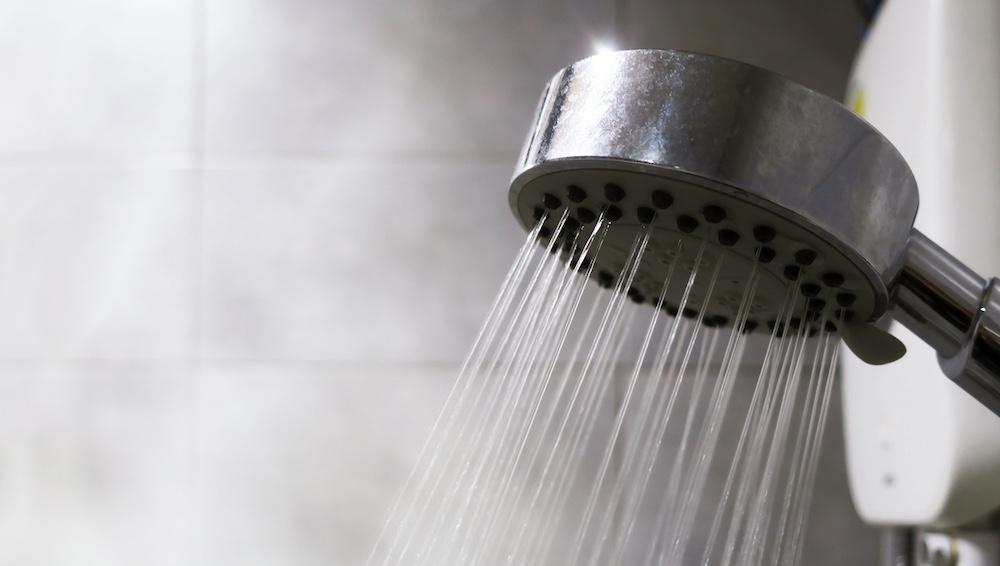 A shower running in a bathroom with steam.