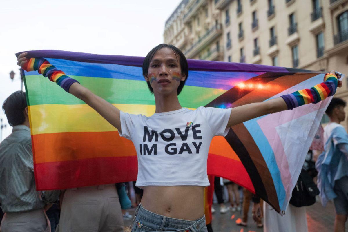 A person poses with a rainbow flag during a pride parade