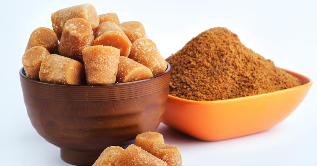 Organic Gur or Jaggery Powder and cubes in bowls on table