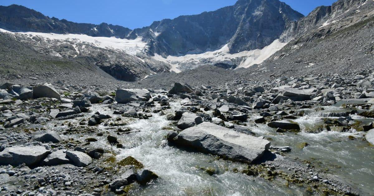 Valley splattered with rubble carved by a retreating glacier on the Adamello Peak in the Alps in Switzerland (Representative Cover Image Source: Getty Images | Michele D Amico Supersky 77)
