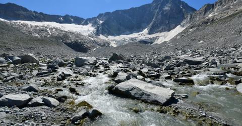 Valley splattered with rubble carved by a retreating glacier on the Adamello Peak in the Alps in Switzerland (Representative Cover Image Source: Getty Images | Michele D Amico Supersky 77)