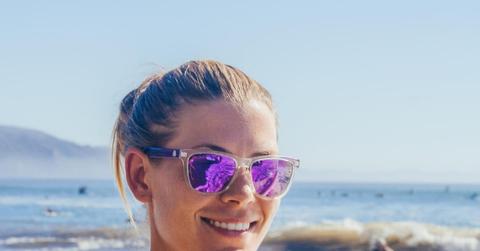 woman at beach with tinted sunglasses