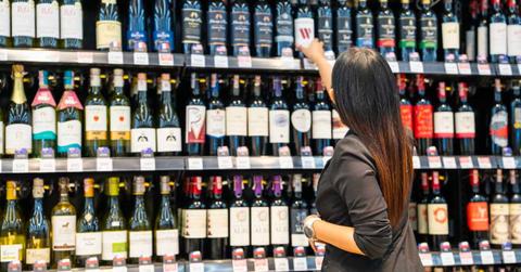 A woman is purchasing wine at a retail store. (Representative Cover Image Source: Getty Images | Witthaya Prasongsin)