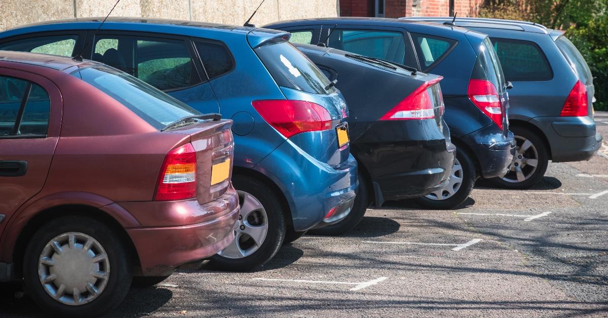 Five cars parked in a parking lot. 