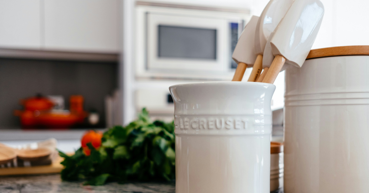 A closeup of white Le Creuset baking utensils